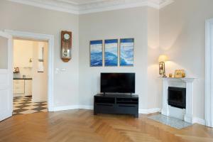 a living room with a television and a fireplace at Elite Apartments Sopot Admiralski przy plaży in Sopot