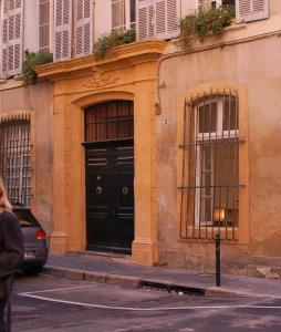 um edifício com uma porta preta e duas janelas em Coeur de ville em Aix-en-Provence