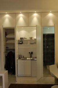 uma cozinha com armários brancos e uma porta de vidro em Coeur de ville em Aix-en-Provence