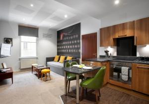 a kitchen and living room with a table and a couch at Stewart by Heeton Concept - Aparthotel Edinburgh in Edinburgh
