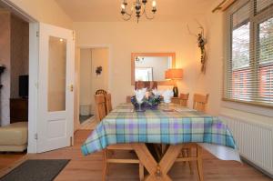 a dining room table with a plaid table cloth at Cedar Cottage in Dunoon