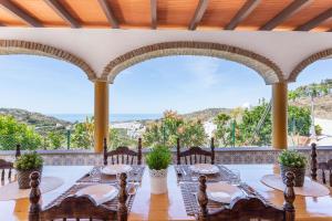 comedor con mesa y sillas con vistas en Cortijo Tomé, en Torrox