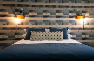 1 dormitorio con 1 cama con 2 luces y 2 almohadas en Hotel Boutique Restaurant Kran Kreen, en Punta Arenas