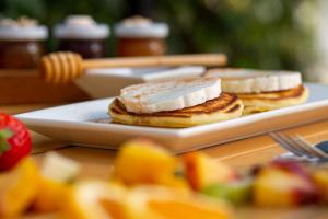two pancakes on a plate on a table with fruit at Pavlos Hotel in Kos Town