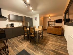 a kitchen and living room with a table and chairs at Le Cabanon de LaFermeDuNol in La Bresse