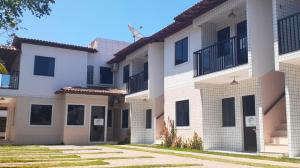 a large white building with black windows and grass at Loca da Lagosta in Barra Grande