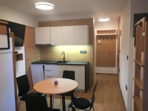 a small kitchen with a table and a table and chairs at Apartma Rogla - Gaber 98 in Resnik