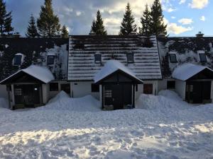 a building covered in snow with snow around it at Apartma Rogla - Gaber 98 in Resnik