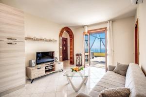 a living room with a couch and a tv at Magdalene's House - sea view terrace in Massa Lubrense