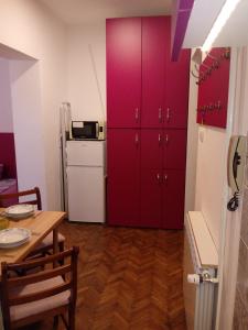 a kitchen with red lockers and a table and a kitchen with a table at Slavija Square in Belgrade