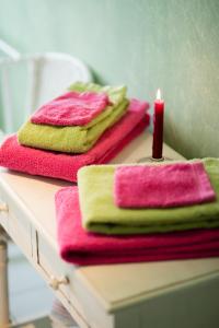 stos ręczników i świeca na stole w obiekcie B&B La Ferme de l'Airbois w mieście Yvoir