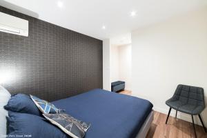 a bedroom with a blue bed and a chair at Le Juliette in Lyon