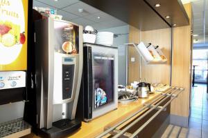 a kitchen with a refrigerator with a drink machine at B&B HOTEL Maubeuge-Louvroil in Louvroil