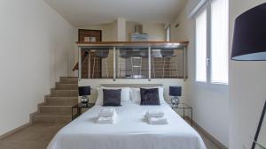 sypialnia z dużym białym łóżkiem i schodami w obiekcie Erïk Langer Pedrocchi Suites w Padwie