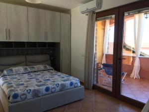 a bedroom with a bed and a sliding glass door at A WINDOW ON THE SEA in Nebida