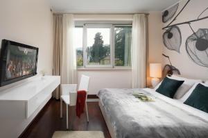1 dormitorio con 1 cama, TV y ventana en Villa Arentz Residence - Front Sea Apartments, en Opatija