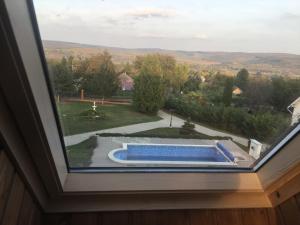 ventana con vistas a la piscina en Villa Teleki, en Teleki