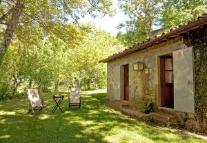 a house with two chairs and a table in the yard at Casa Dell'Ambasciatore in Vivo dʼOrcia