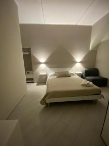 a bedroom with a bed and a couch and lights at B&B Il Vicoletto in Castellammare di Stabia