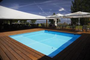 a swimming pool on a deck with an umbrella at Järveveere Puhkekeskus in Valma