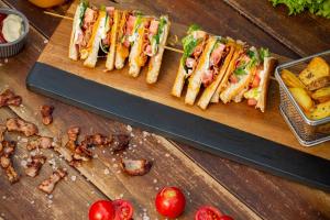 a group of sandwiches on a wooden cutting board at Pavlos Hotel in Kos Town