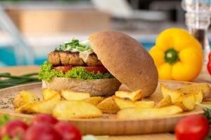 a sandwich on a plate with chips and fruit at Pavlos Hotel in Kos Town