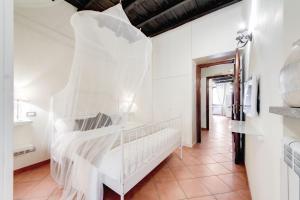 una camera da letto con un grande letto con lenzuola bianche di Elegant Apartment Behind the Colosseum a Roma