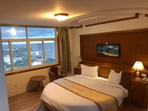 een hotelkamer met een bed en een raam bij Sea Light Hotel in Rach Gia