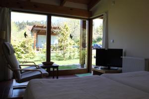 1 dormitorio con 2 camas, TV y ventana en Bungalow Camping Los Manzanos, en Santa Cruz de Oleiros