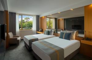イスタンブールにあるタン ホテル スペシャルカテゴリーのベッド2台とテレビが備わるホテルルームです。