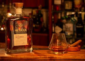 a bottle of whiskey and a glass on a table at Pavlos Hotel in Kos Town