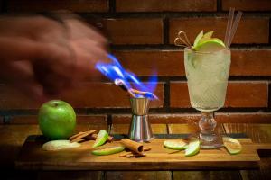 a drink on a wooden table with an apple and a drink at Pavlos Hotel in Kos Town