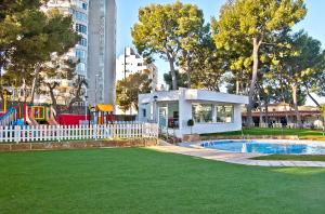 a playground in a park with a pool and a building at BQ Belvedere Hotel in Palma de Mallorca