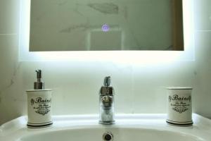 lavabo con 2 dispensadores de jabón y espejo en Marias Home in Blloku, Tirana, en Tirana 14 fotos más