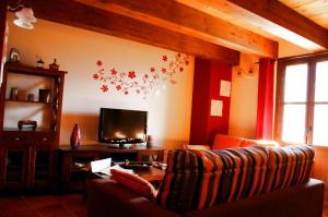 a living room with a couch and a flat screen tv at Casa Villamana in Oto