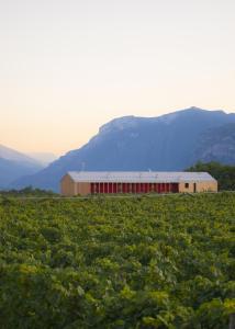 un granero en un campo con montañas en el fondo en 8 Grappoli Agritur en Trento