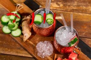 a wooden table with two drinks and some vegetables at Pavlos Hotel in Kos Town