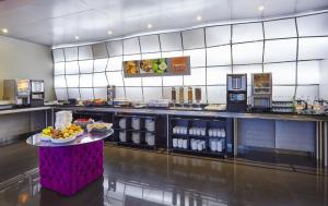 a restaurant with a counter with food and drinks at Holiday Inn Express Lisbon Alfragide, an IHG Hotel in Alfragide