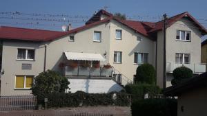 een huis met een balkon met bloemen erop bij Pokoje gościnne Akacja Resko in Dźwirzyno