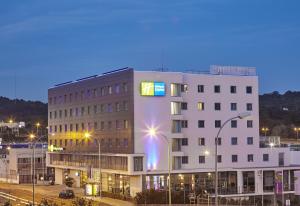 un grand bâtiment blanc dans une ville la nuit dans l'établissement Holiday Inn Express Lisbon Alfragide, an IHG Hotel, à Alfragide