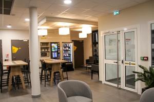 a waiting room with tables and chairs in a building at B&B HOTEL Montélimar Sud in Montélimar