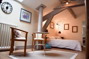 Saint-Sever的住宿－Les Écuries de Saint Sever，卧室配有一张床,墙上挂着一个钟