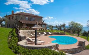 a swimming pool in front of a house at Villa dei Tramonti in Passignano sul Trasimeno