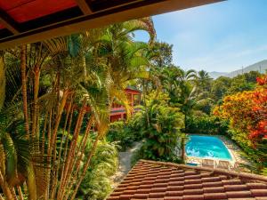 a view of a resort with a swimming pool and palm trees at Pousada Ecoilha in Ilhabela