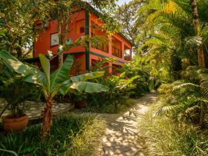 an orange house with trees and plants in front of it at Pousada Ecoilha in Ilhabela