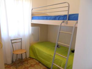 ein Schlafzimmer mit einem Etagenbett, einer Leiter und einem Stuhl in der Unterkunft Condominio Carina in Bibione