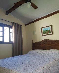 Un dormitorio con una cama y un ventilador de techo. en Pousada Lírio do Campo, en São Pedro da Serra 8 fotos más