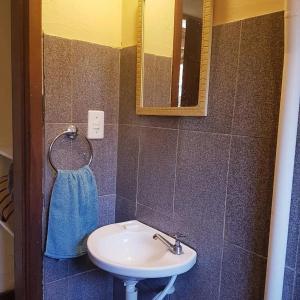 La salle de bains est pourvue d'un lavabo et d'un miroir. dans l'établissement Pousada Lírio do Campo, à São Pedro da Serra