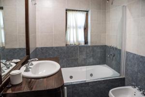 a bathroom with a tub and a sink and a shower at Estancia Del Carmen Mountain Resort in San Carlos de Bariloche