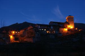 un grupo de casas iluminadas por la noche en Casa Villamana en Oto
